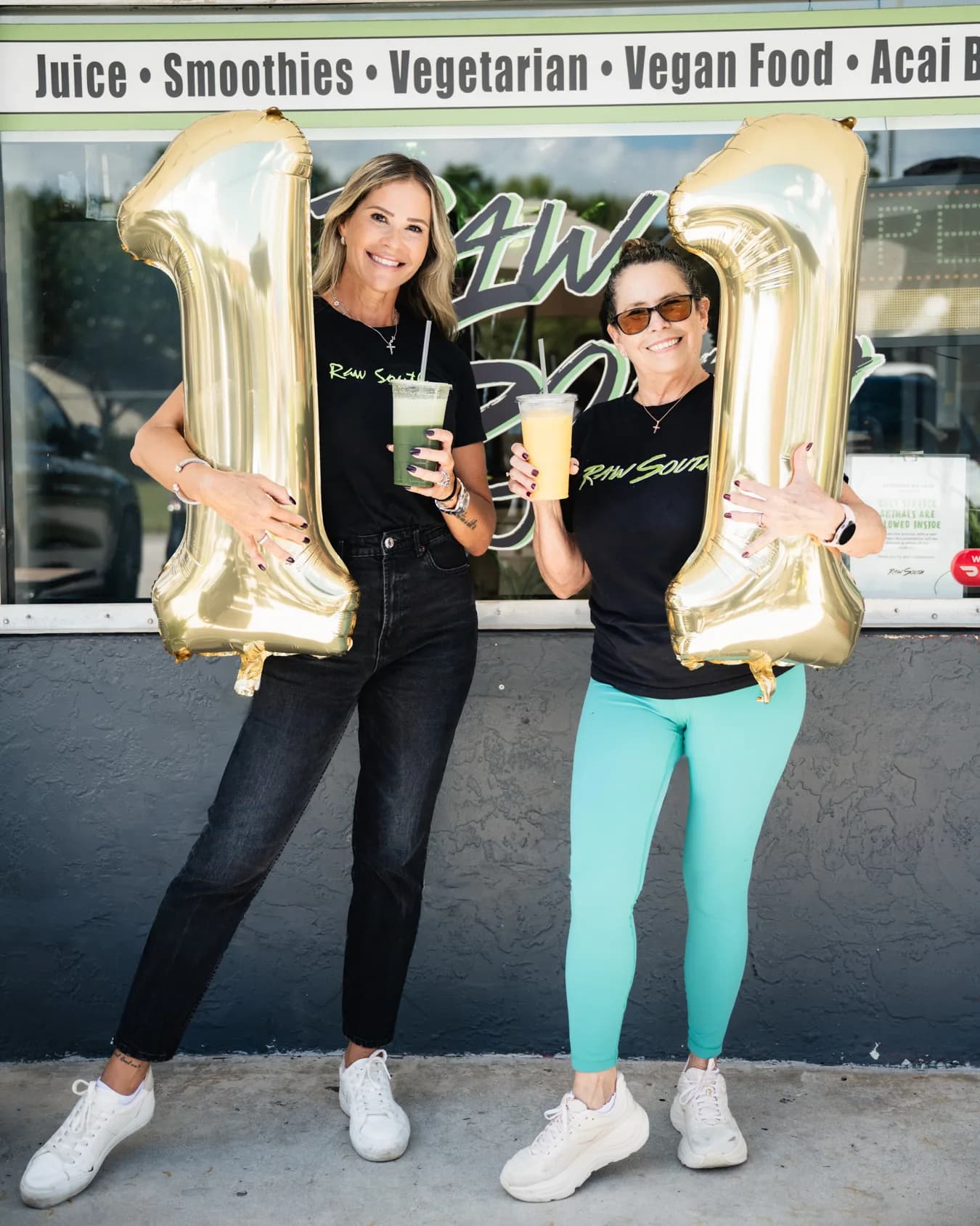 Two team members celebrating outside Raw South Juice Co.