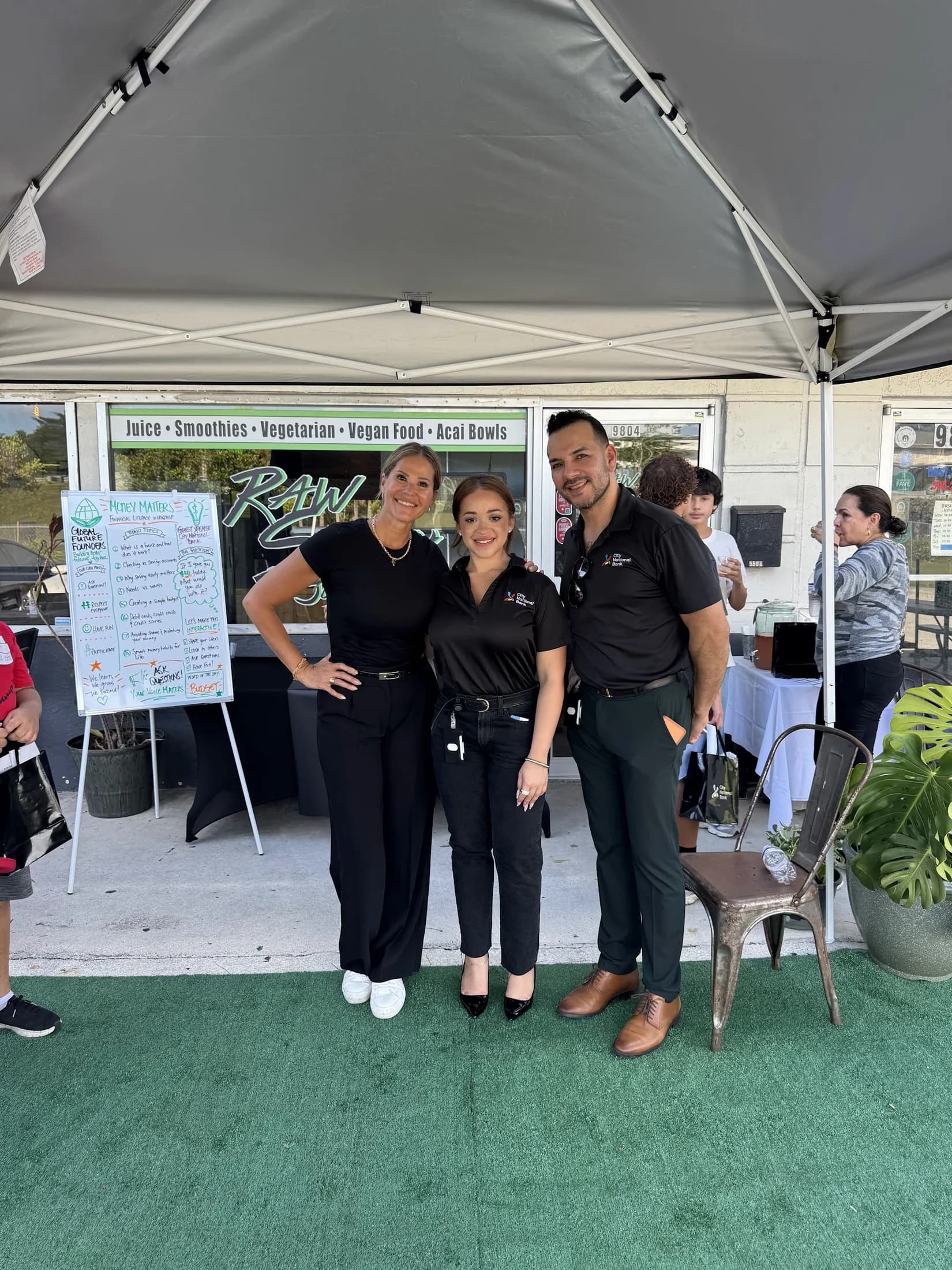 Yesenia Gomez with community partners at an outdoor program tent.