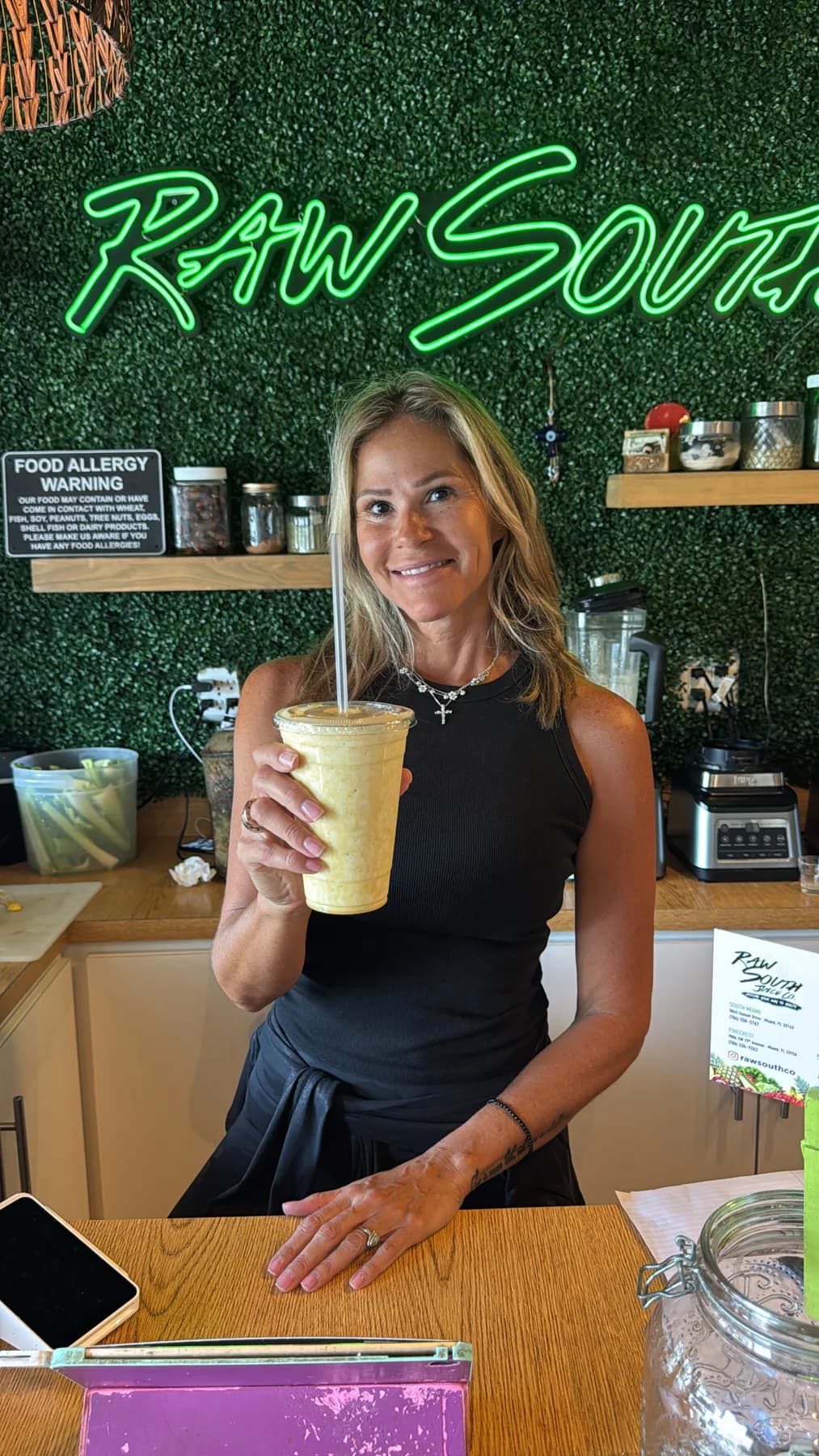 Yesenia Gomez holding a Raw South drink inside the juice bar.