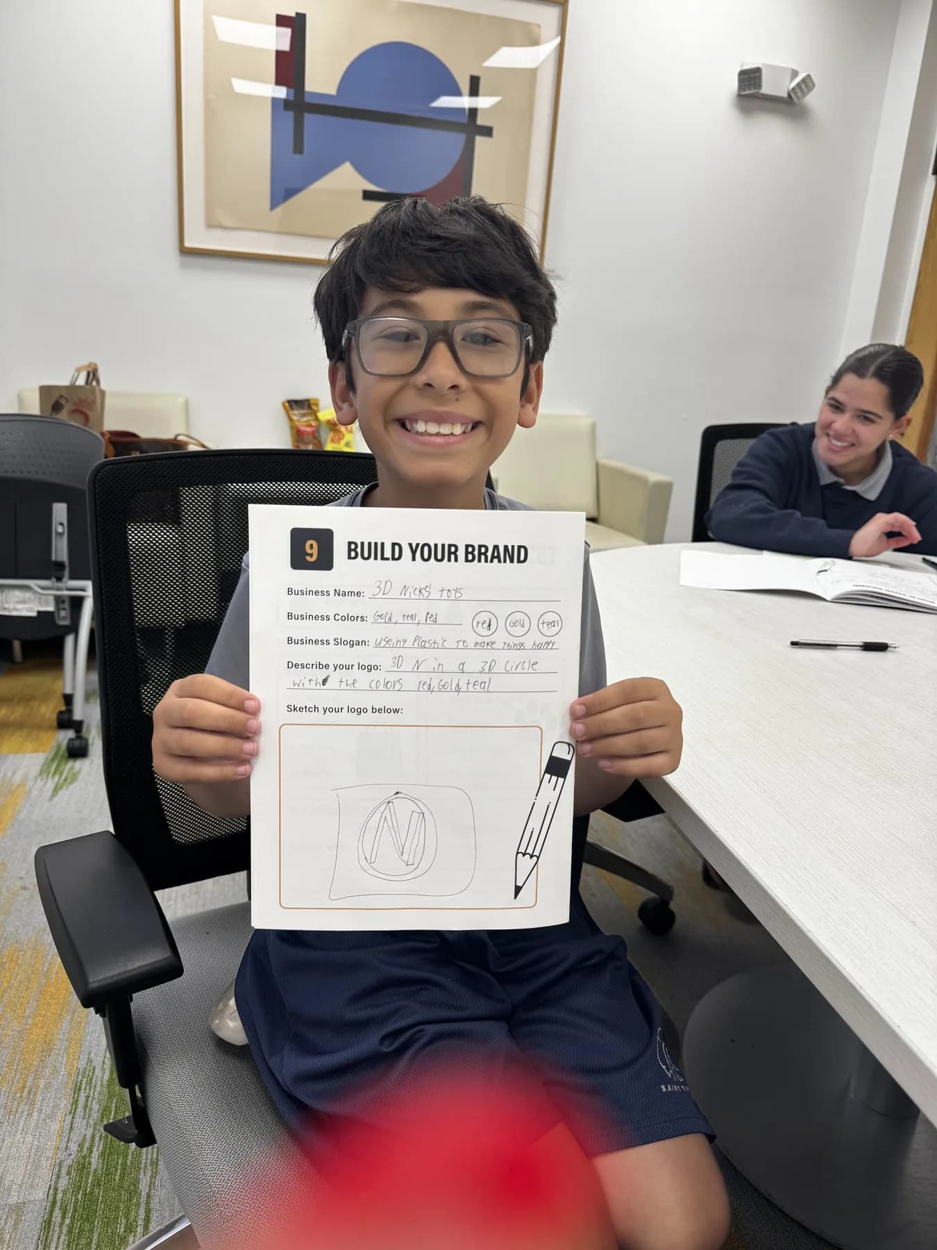 A student smiling while holding a Future Founders worksheet.