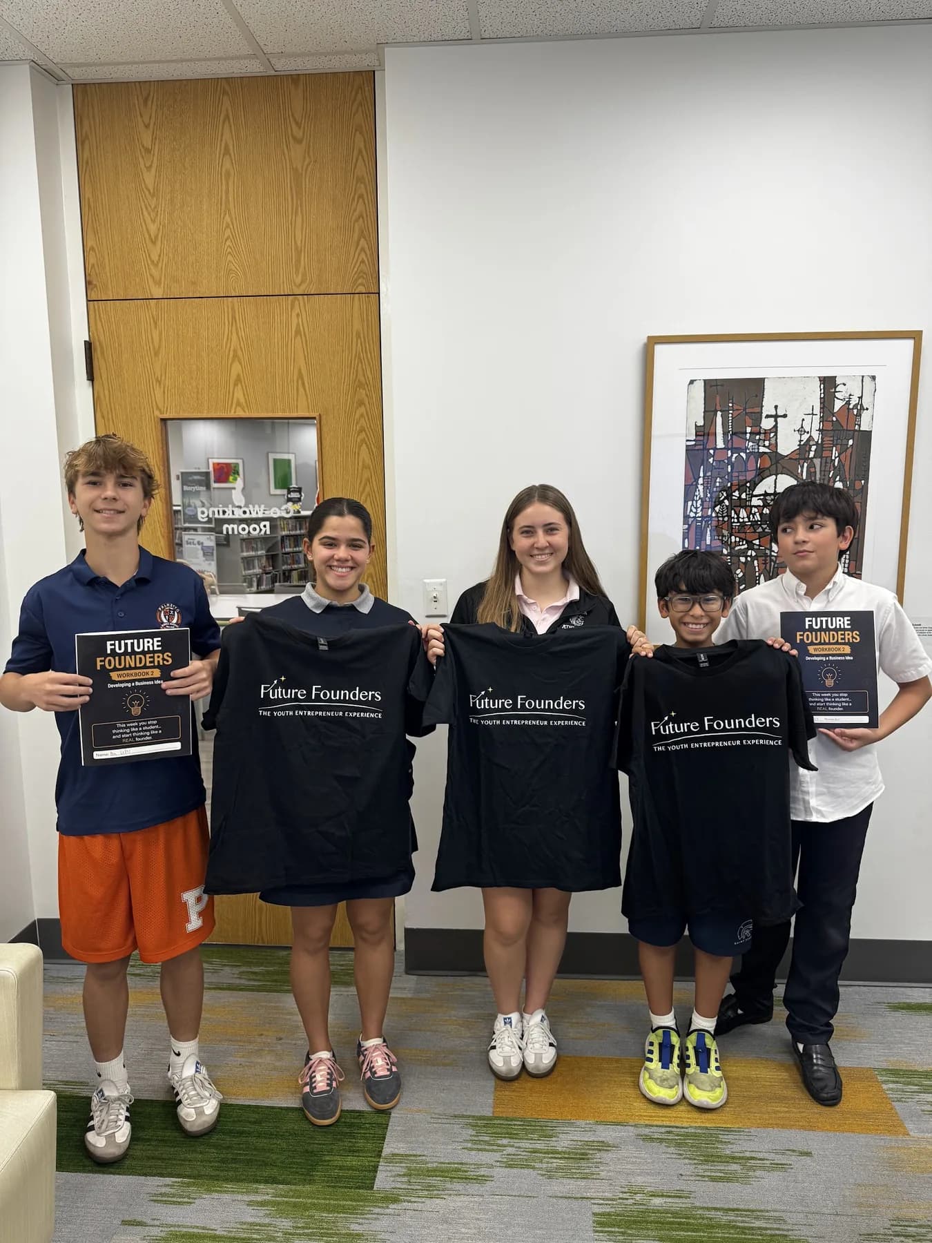 A group of students wearing Future Founders aprons and holding certificates.